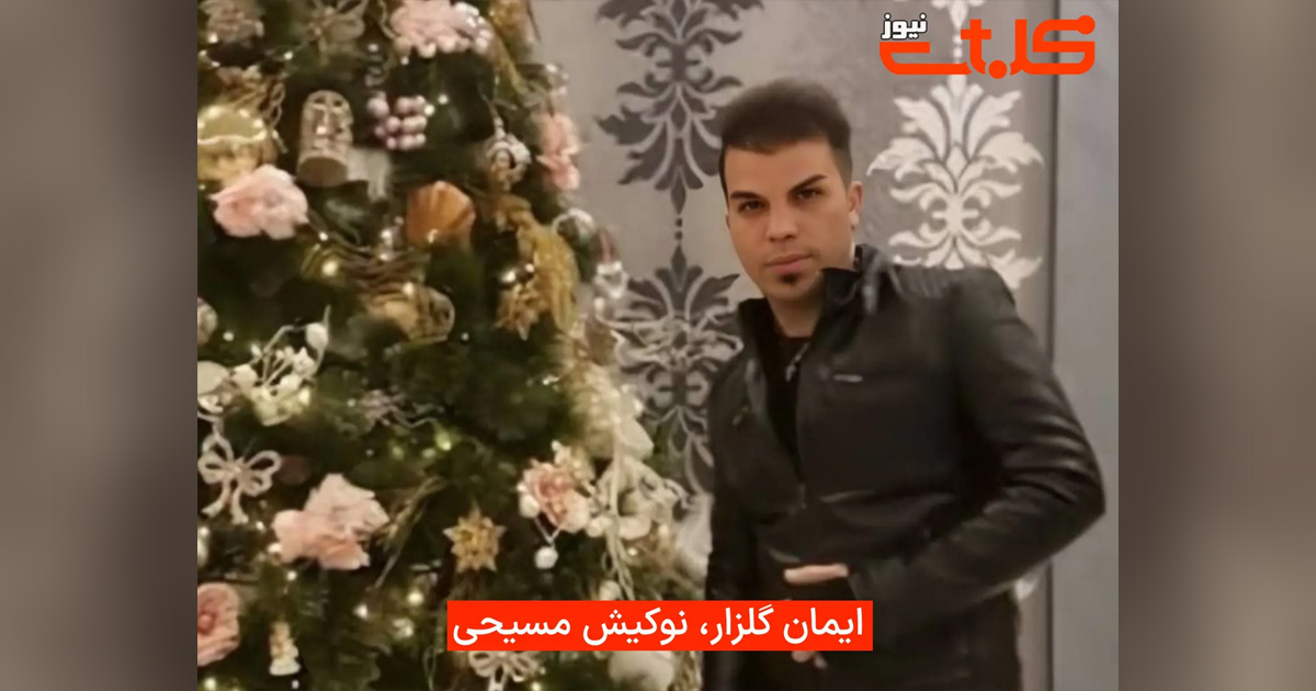 Iman Golzar is standing next to a Christmas tree.