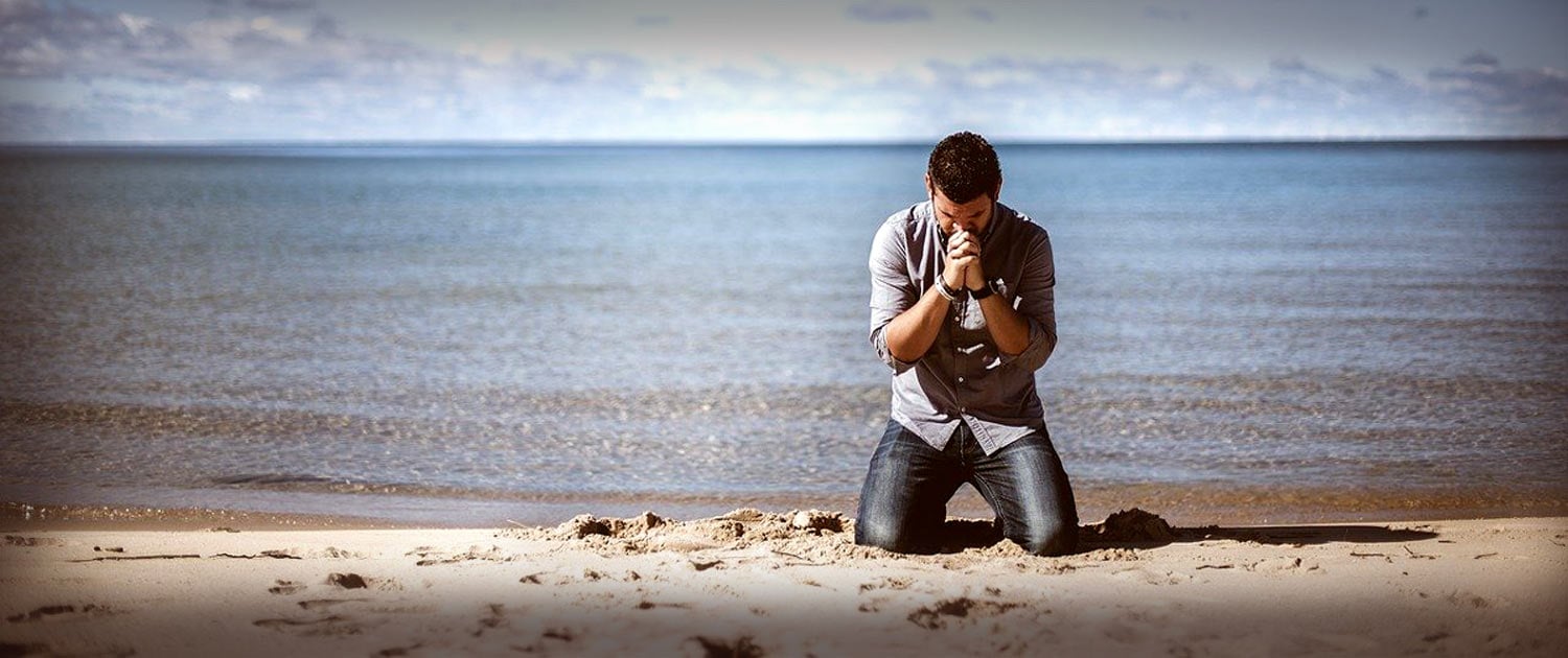 Man praying on the beach