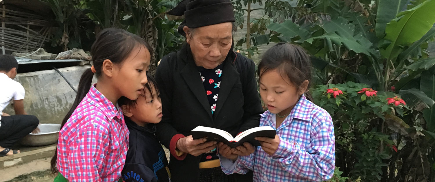 Vietnam - Elder Christian reading the Bible with children - Photo: VOMC